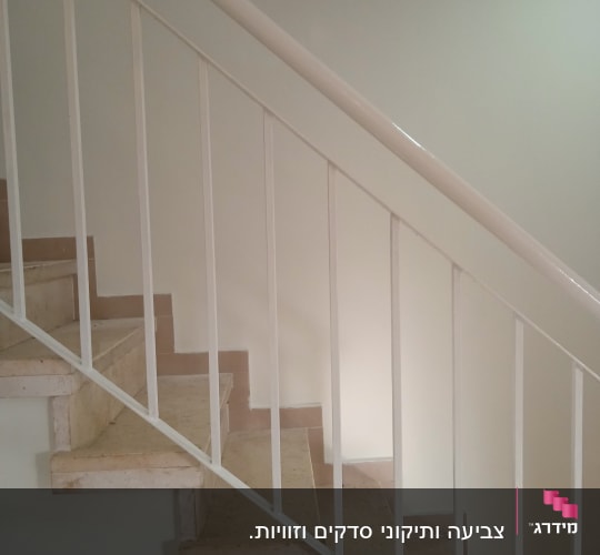 מעקה מדרגות צבוע בלבן עם קיר צבוע